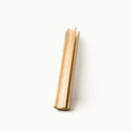 A single light natural wood rectangular block or trim piece standing upright on a plain white background.